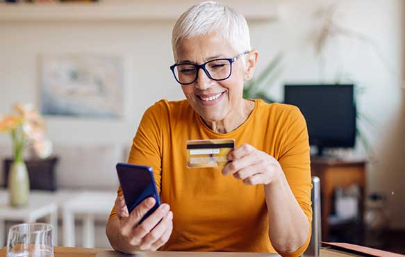 Person using check card while shopping on their phone.