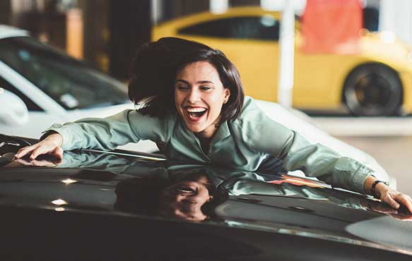 Woman hugging her new car.