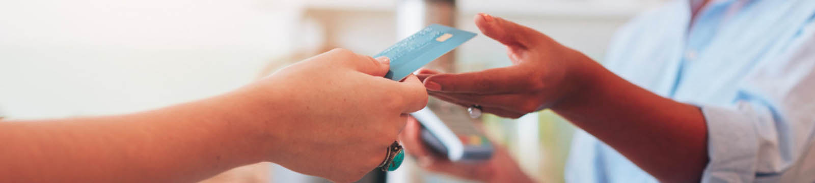 Person handing salesperson a credit card.