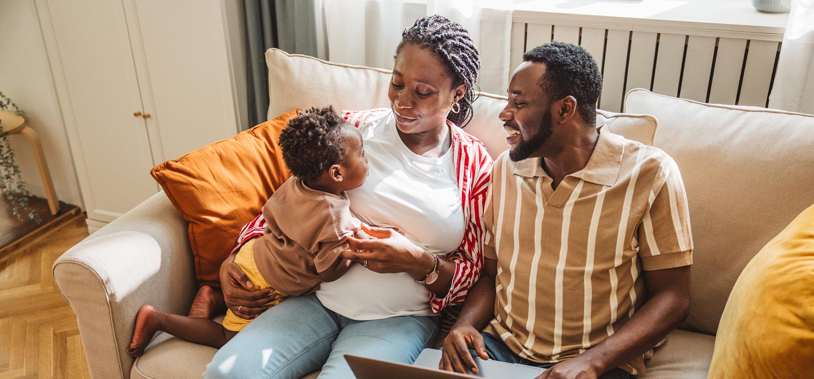 Young family using laptop in living room