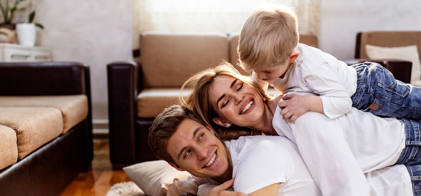 Young couple playing with son in living room