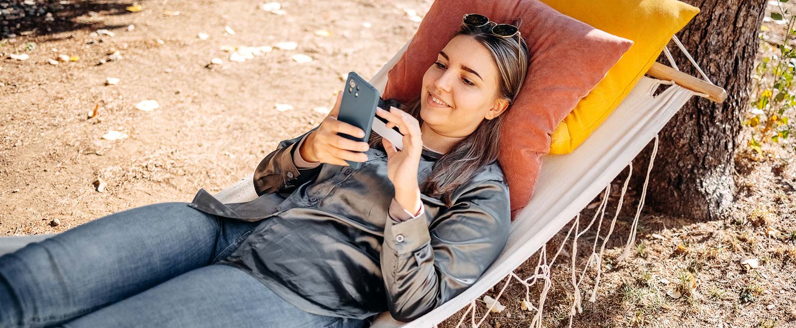 Woman using cell phone in hammock